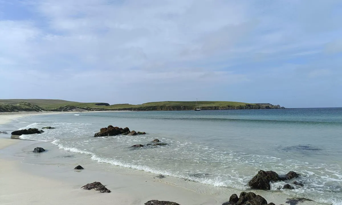 Bay of Scousburgh: {"base": "en", "no": "Ser vestover langs stranden", "se": "Ser v\u00e4sterut l\u00e4ngs stranden", "en": "Looking West along the beach", "da": "Kigger mod vest langs stranden"}