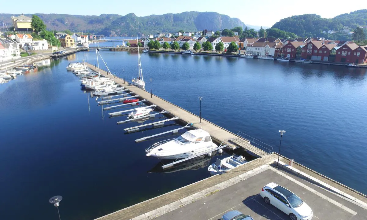 Her ser vi flytebryggen som ligger på landsiden i Farsund og i bakgrunnen er det longside fortøying til kai på Gåseholmen.