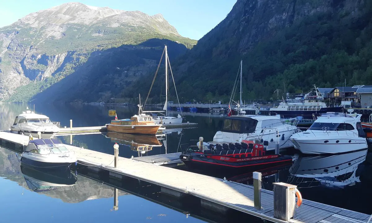 Geirangerfjorden Marina: {"base": "no", "no": "Gjestebrygga sett fra land.", "se": "G\u00e4stbryggan sedd fr\u00e5n land.", "en": "Guest pier seen from land.", "da": "G\u00e6stebroen set fra land."}