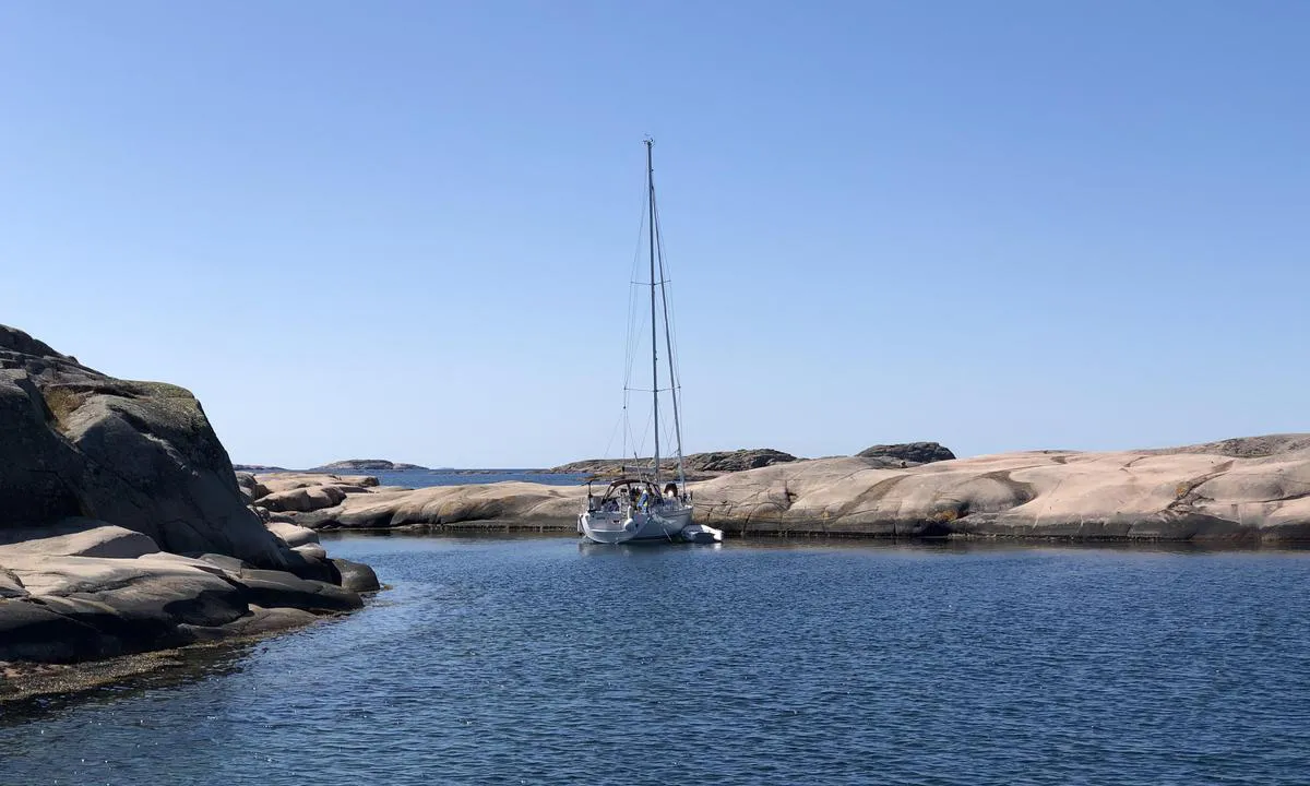 Sailboat towards land on Gråskär. Sandy seabed and bolts on land.