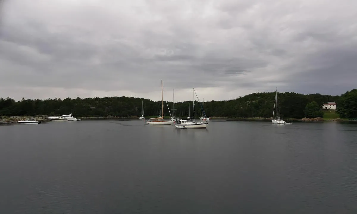 Hui - Eneboeren: Ankringsplassen sett fra syd. Hudøy feriekoloni til høyrei bildet.
Geitungholmen med noen båter fortøyd til venstre i bildet. 
Seilbåter med dyptgående ca 195 vil vanskelig finne longsideplass på Geitungholmen øst, men det finnes et par.