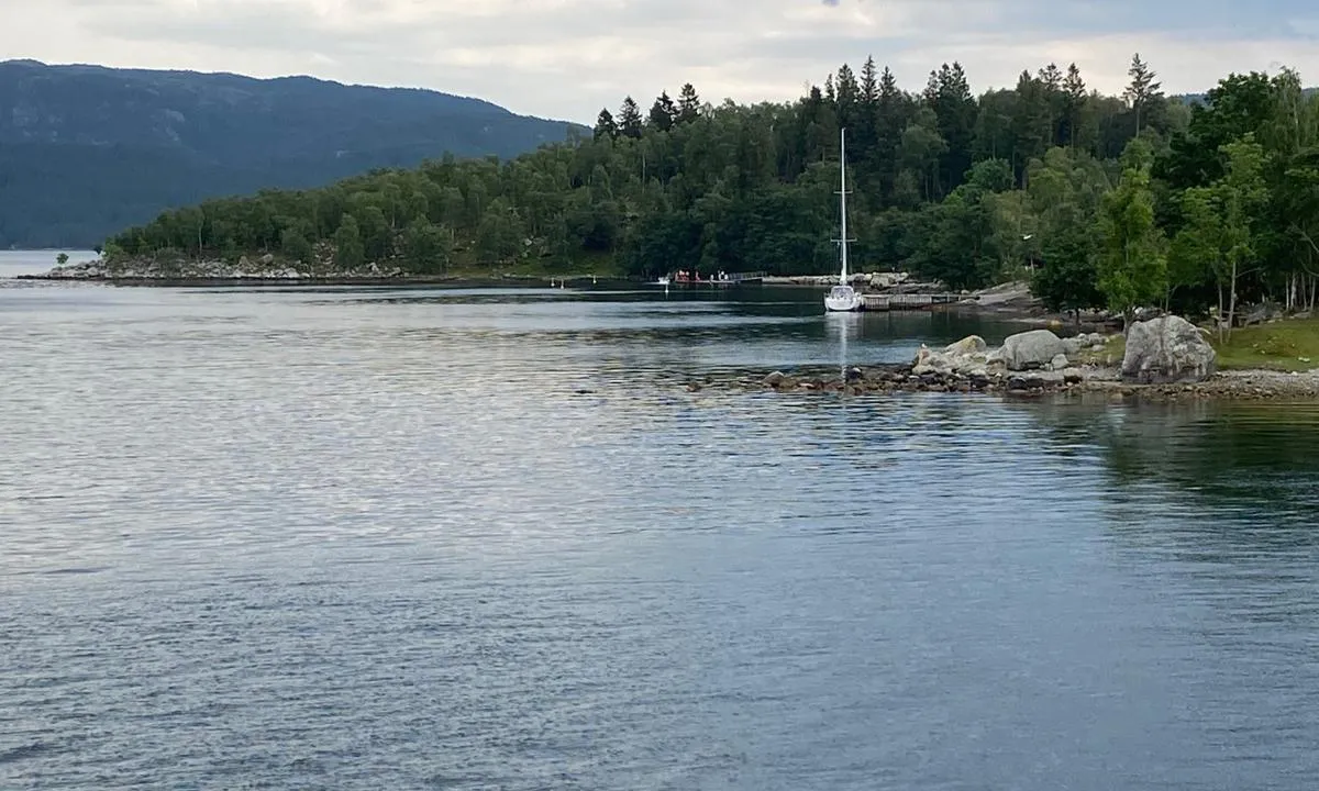 Jørpelandsholmen: Båten ligger ved trebrygga. Badebrygge litt lenger sør i bukta.