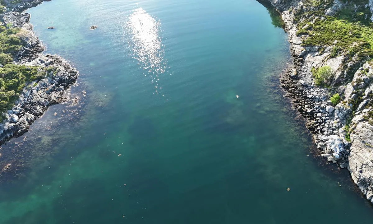 Kalsundholmen Austevoll: {"base": "no", "no": "Dronefoto av sundet inn til lagunen. Jeg m\u00e5lte ca. 4 meter p\u00e5 dybdeloggen midt i sundet p\u00e5 det grunnneste.", "se": "<em>Dr\u00f6narfoto av sundet in till lagunen. Jag m\u00e4tte ca. 4 meter p\u00e5 djupm\u00e4taren mitt i sundet d\u00e4r det var som grundast.</em>", "en": "Drone photo of the strait into the lagoon. I measured approximately 4 meters on the depth log at the shallowest point in the middle of the strait.", "da": "<em>Dronefoto av sundet inn til lagunen. Jeg m\u00e5lte ca. 4 meter p\u00e5 dybdeloggen midt i sundet p\u00e5 det grundigste.</em>"}