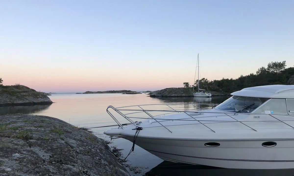 Kalvøyhavn: Utsikten er mot syd. Plassen i bukta med seilbåten er veldig populær. Her legger en seg på trosse til land både forut og akterut.
Svaberget ved motorbåten er som en brygge.
