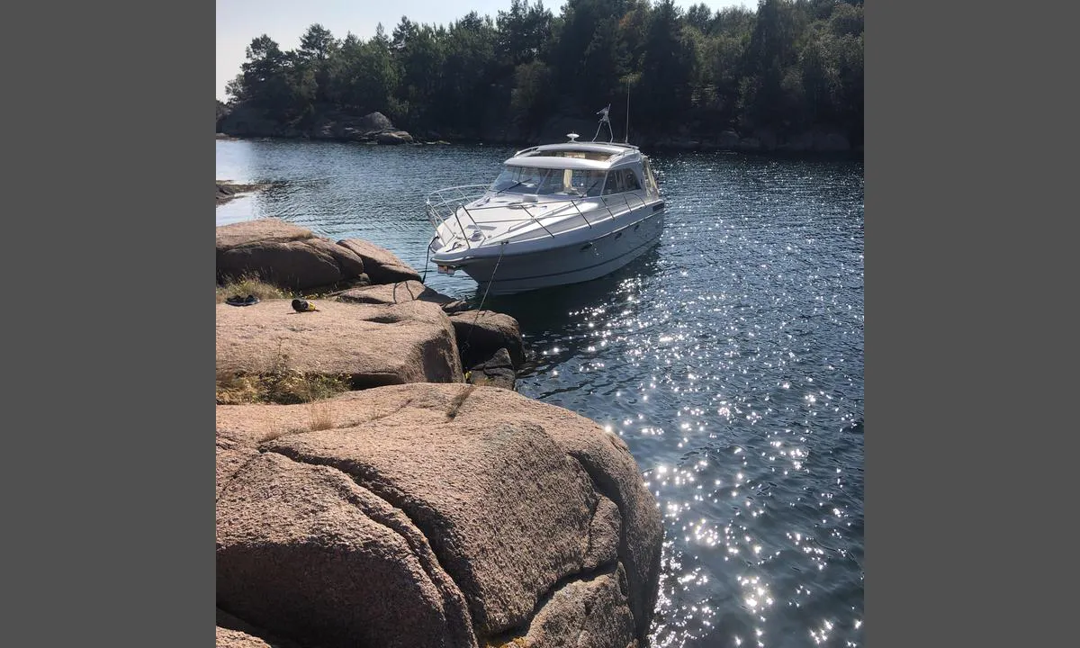 Kråkeholmen: Bildet er tatt i mot syd, mot Skarvøy.
En kan legge seg longside opp i mot den naturlige steinbrygga, eller dregge. Bruk kiler.
Sandbunn.