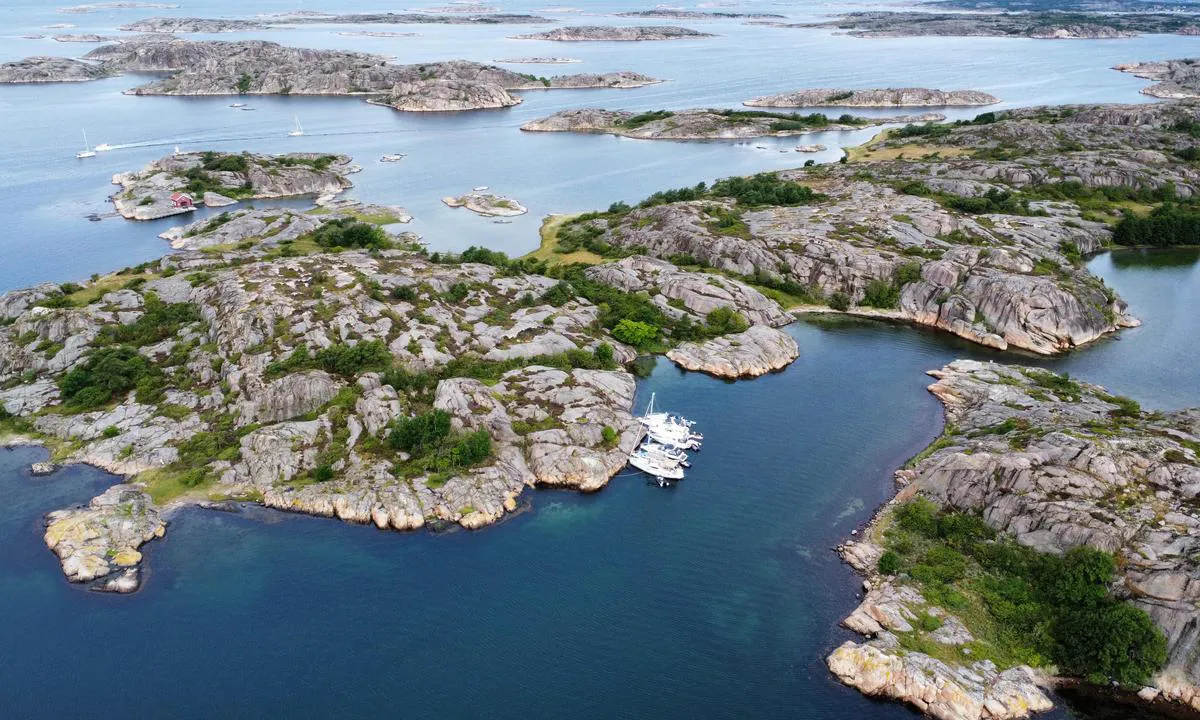 Several boats moored with the bow towards the rocks on The south east side of Lilla Köttö.