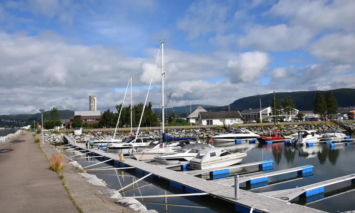 Moholmen Marina - Mo i Rana: {"base": "no", "no": "P\u00e5 innsiden av moloen, det hvite huset i bakgrunnen er servicebygget.", "se": "P\u00e5 insidan av piren, det vita huset i bakgrunden \u00e4r servicebyggnaden.", "en": "On the inside of the breakwater, the white house in the background is the service building.", "da": "P\u00e5 indersiden af molen, det hvide hus i baggrunden er servicebygningen."}
