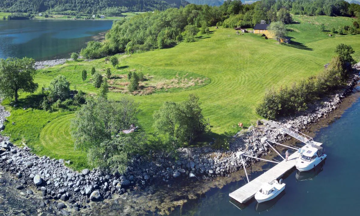 Raudøya: {"base": "no", "no": "Dronebilde mai 2024. Ser her begge flytebryggene p\u00e5 Raud\u00f8ya/Raud\u00f8yna.", "se": "Dr\u00f6narbild maj 2024. Ser h\u00e4r b\u00e5da flytbryggorna p\u00e5 Raud\u00f8ya/Raud\u00f8yna.", "en": "Drone image May 2024. Here you can see both floating docks at Raud\u00f8ya/Raud\u00f8yna.", "da": "<i>Dronebillede maj 2024. Ser her begge flydebroerne p\u00e5 Raud\u00f8ya/Raud\u00f8yna.</i>"}