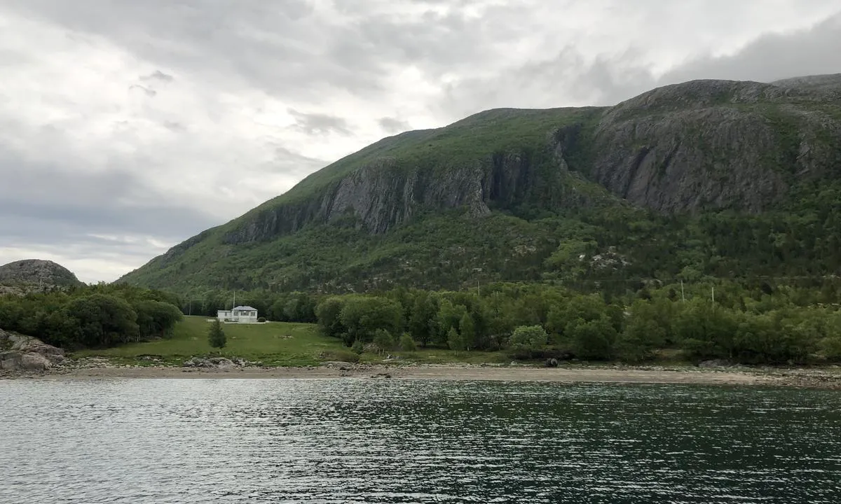 Rossvika ligger under de frodige og massive fjellene på øya Austra.