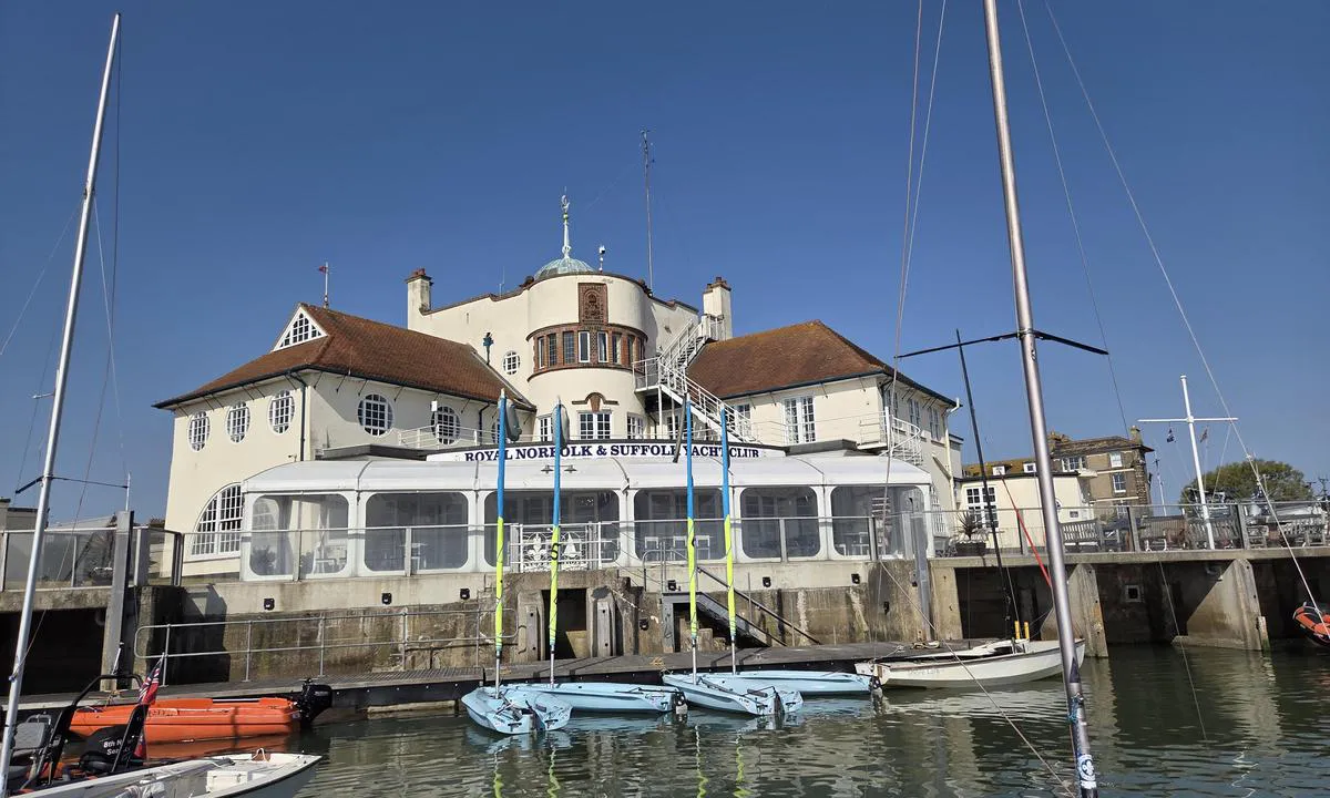 Royal Norfolk and Suffolk Yacht Club: {"base": "no", "no": "Flott historisk hovedbygning", "se": "Fin historisk huvudbyggnad", "en": "Beautiful historic main building", "da": "Flot historisk hovedbygning", "fr": "Magnifique b\u00e2timent principal historique", "de": "Gro\u00dfartiges historisches Hauptgeb\u00e4ude", "es": "Imponente edificio principal hist\u00f3rico", "it": "Splendido edificio principale storico", "pt": "Edif\u00edcio principal hist\u00f3rico maravilhoso", "nl": "Geweldig historisch hoofdgebouw", "pl": "Wspania\u0142y historyczny budynek g\u0142\u00f3wny", "uk": "\u0427\u0443\u0434\u043e\u0432\u0430 \u0456\u0441\u0442\u043e\u0440\u0438\u0447\u043d\u0430 \u0433\u043e\u043b\u043e\u0432\u043d\u0430 \u0431\u0443\u0434\u0456\u0432\u043b\u044f", "ro": "Cl\u0103dire principal\u0103 istoric\u0103 magnific\u0103", "tr": "Harika tarihi ana bina", "el": "\u03a5\u03c0\u03ad\u03c1\u03bf\u03c7\u03bf \u03b9\u03c3\u03c4\u03bf\u03c1\u03b9\u03ba\u03cc \u03ba\u03cd\u03c1\u03b9\u03bf \u03ba\u03c4\u03af\u03c1\u03b9\u03bf", "cs": "Kr\u00e1sn\u00e1 historick\u00e1 hlavn\u00ed budova", "hu": "Nagy t\u00f6rt\u00e9nelmi f\u0151\u00e9p\u00fclet", "fi": "Upea historiallinen p\u00e4\u00e4rakennus", "bg": "\u041f\u0440\u0435\u043a\u0440\u0430\u0441\u043d\u0430 \u0438\u0441\u0442\u043e\u0440\u0438\u0447\u0435\u0441\u043a\u0430 \u0433\u043b\u0430\u0432\u043d\u0430 \u0441\u0433\u0440\u0430\u0434\u0430", "sr": "Prekrasna istorijska glavna zgrada", "et": "Suurep\u00e4rane ajalooline peahoone", "lv": "Lieliska v\u0113sturiski galven\u0101 \u0113ka", "lt": "Nuostabus istorinis pagrindinis pastatas"}