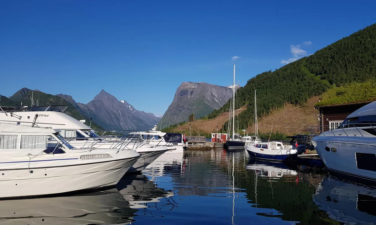 Sæbø: {"base": "no", "no": "Bilde fra indre havn, i bakgrunnen fjellet \"Slogen\"", "se": "Bild fr\u00e5n inre hamnen, i bakgrunden berget 'Slogen'", "en": "Image from the inner harbor, in the background the mountain \"Slogen\"", "da": "Billede fra indre havn, i baggrunden bjerget 'Slogen'"}