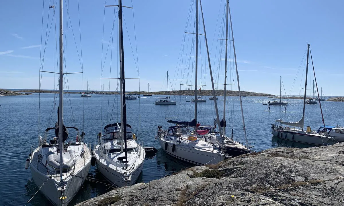 Slubbersholmen: Bilde tatt i sydvestlige retning fra nord (Mollön). Vekslende fortøyning med både bolter og bergkiler her. Tre SXK bøyer like utenfor og svaiplass til mange utenfor dem. I bakgrunnen kan man skimte sandstranden(!) på motsatt side.