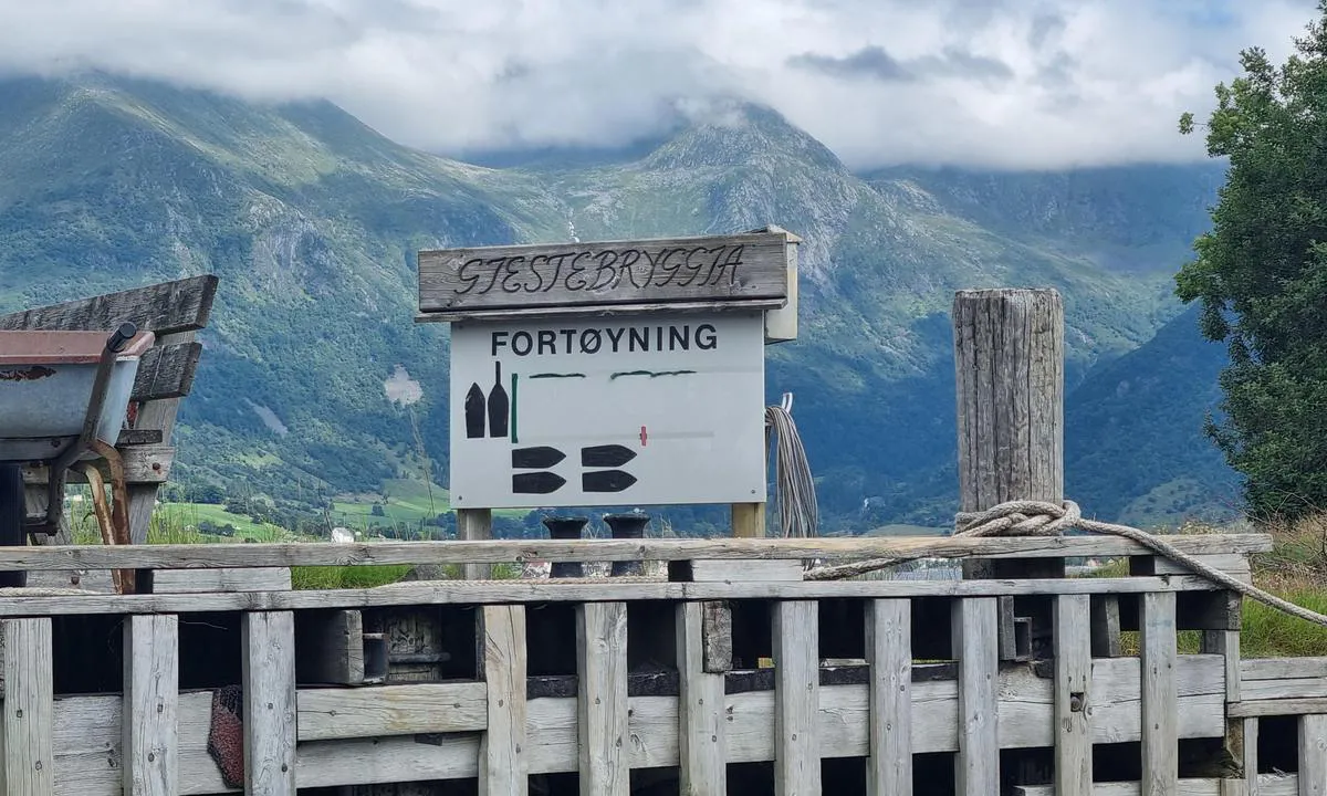 Snilstveitøy - Rosendal: Beskrivelse av gjestebrygge. Det ligger dog en båt fast ved de oransje blåsene