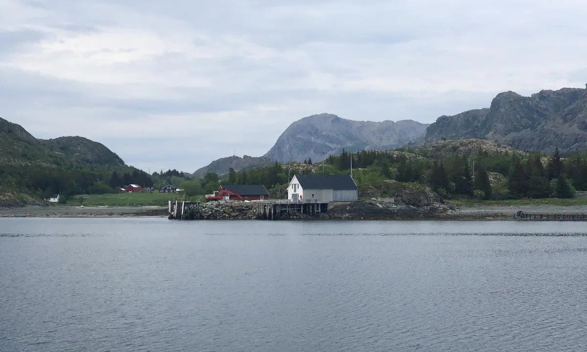 I Solsemvågen er det noen få brygger og naust, og utsikt nordover til fjellene på Leka.