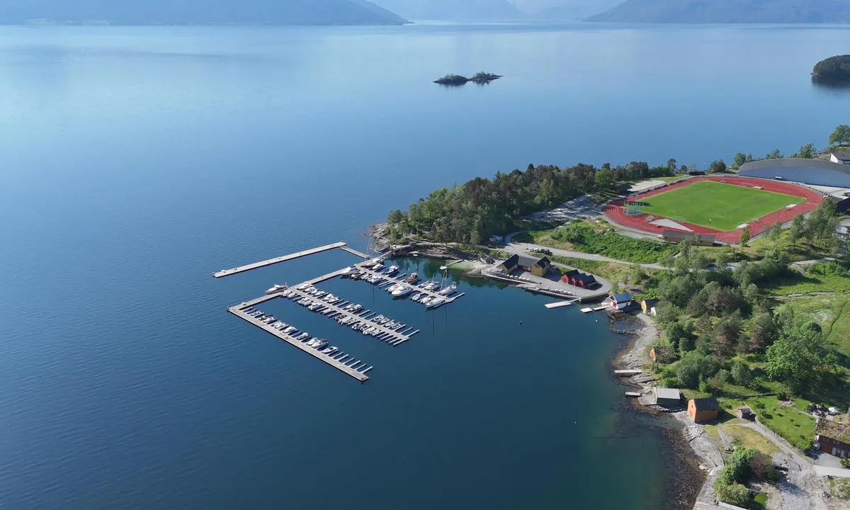 Strandebarm: {"base": "no", "no": "B\u00e5thavn med badestrand og servicebygg. Minigolf, trengingsapparater og idrettsbane lengre bak. Tursti i skogen til venstre.", "se": "B\u00e5thamn med badstrand och servicebyggnad. Minigolf, tr\u00e4ningsapparater och idrottsplats l\u00e4ngre bak. Vandringsled i skogen till v\u00e4nster.", "en": "Marina with beach and service building. Mini golf, exercise equipment, and sports field further back. Hiking trail in the forest to the left.", "da": "B\u00e5dehavn med badestrand og servicebygning. Minigolf, tr\u00e6ningsudstyr og idr\u00e6tsbane l\u00e6ngere bagved. Sti i skoven til venstre."}