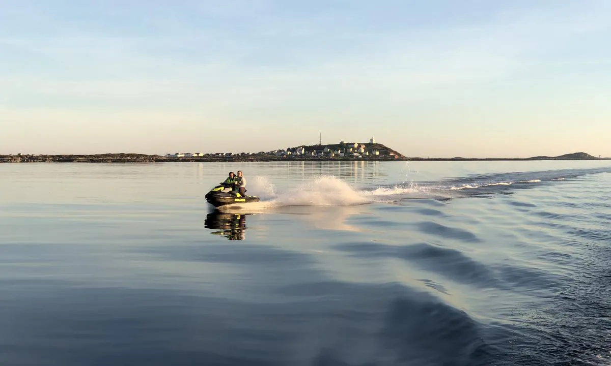 To jenter på vannscooter med Sula i bakrunnen.