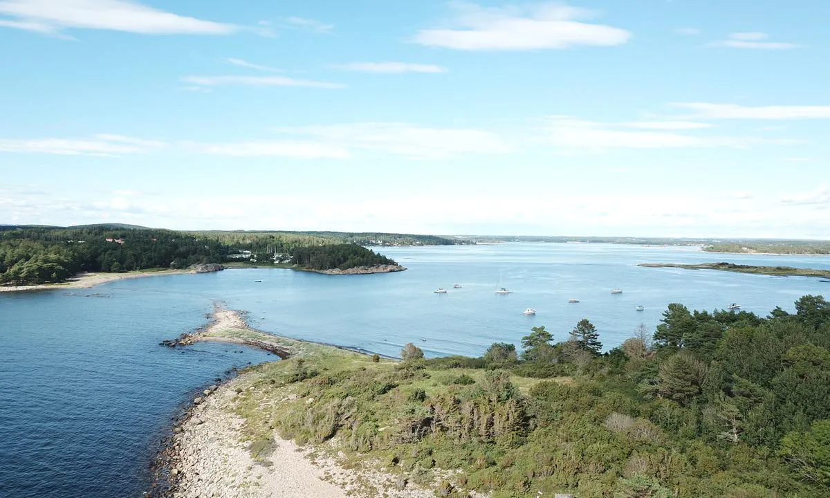 Luftfoto, sett fra sydvest.  Danmark i forgrunnen. Taralden til høyre midt i bildet. I bakgrunnen Oven og Kurefjorden. Øya Danmark er landfast ved fjære sjø og steinrøysa til fastlandet demper bølger fra det sterkt trafikkerte Larkollsundet på nærmest i bildet.