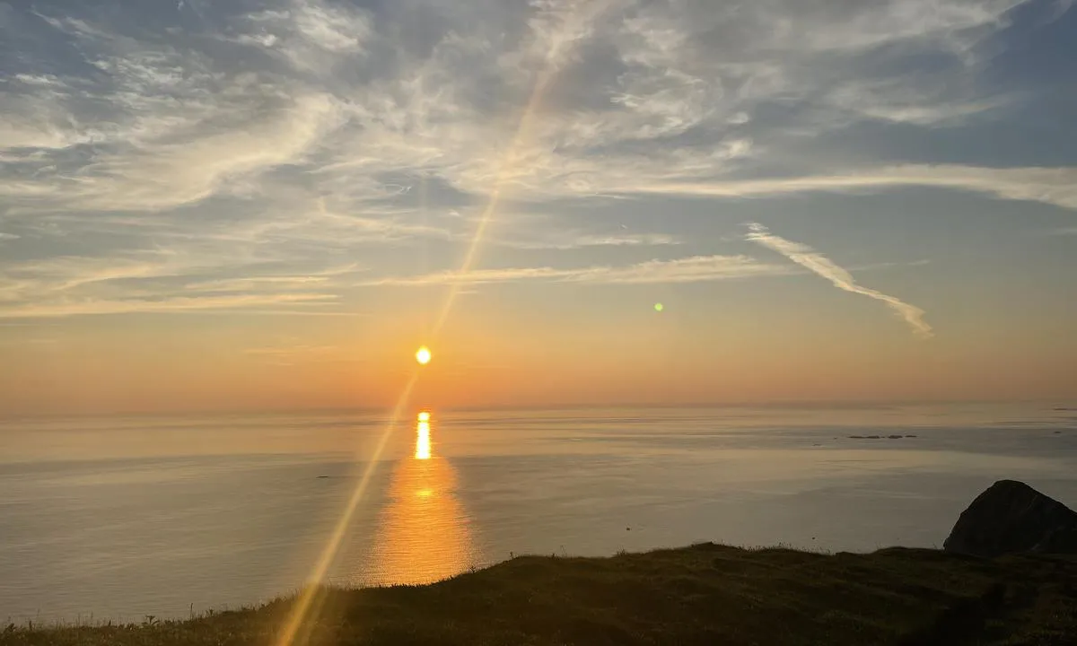 Værøya: {"base": "no", "no": "Midnattssola sett fra H\u00e5heia..", "se": "Midnattssolen sett fr\u00e5n H\u00e5heia.", "en": "The midnight sun seen from H\u00e5heia.", "da": "Midnatssolen set fra H\u00e5heia.."}